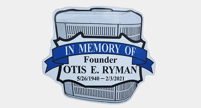 A blue and white sticker with the words " in memory of founder otis e. Ryman 5 / 2 6 / 1 9 4 0 -
